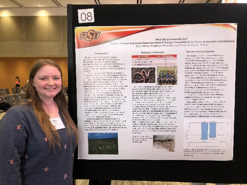 Dana Miller standing in front of her poster presentation.