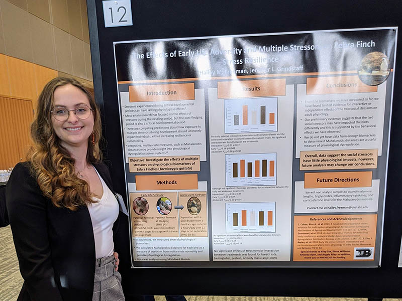 Hailey Freeman standing in front of her poster presentation.