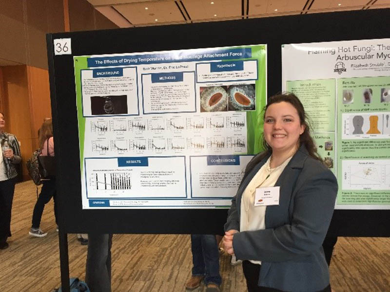 Sara Warren standing in front of her poster presentation.