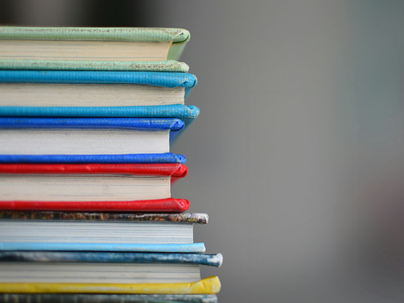 A side view of stacked colorful books.