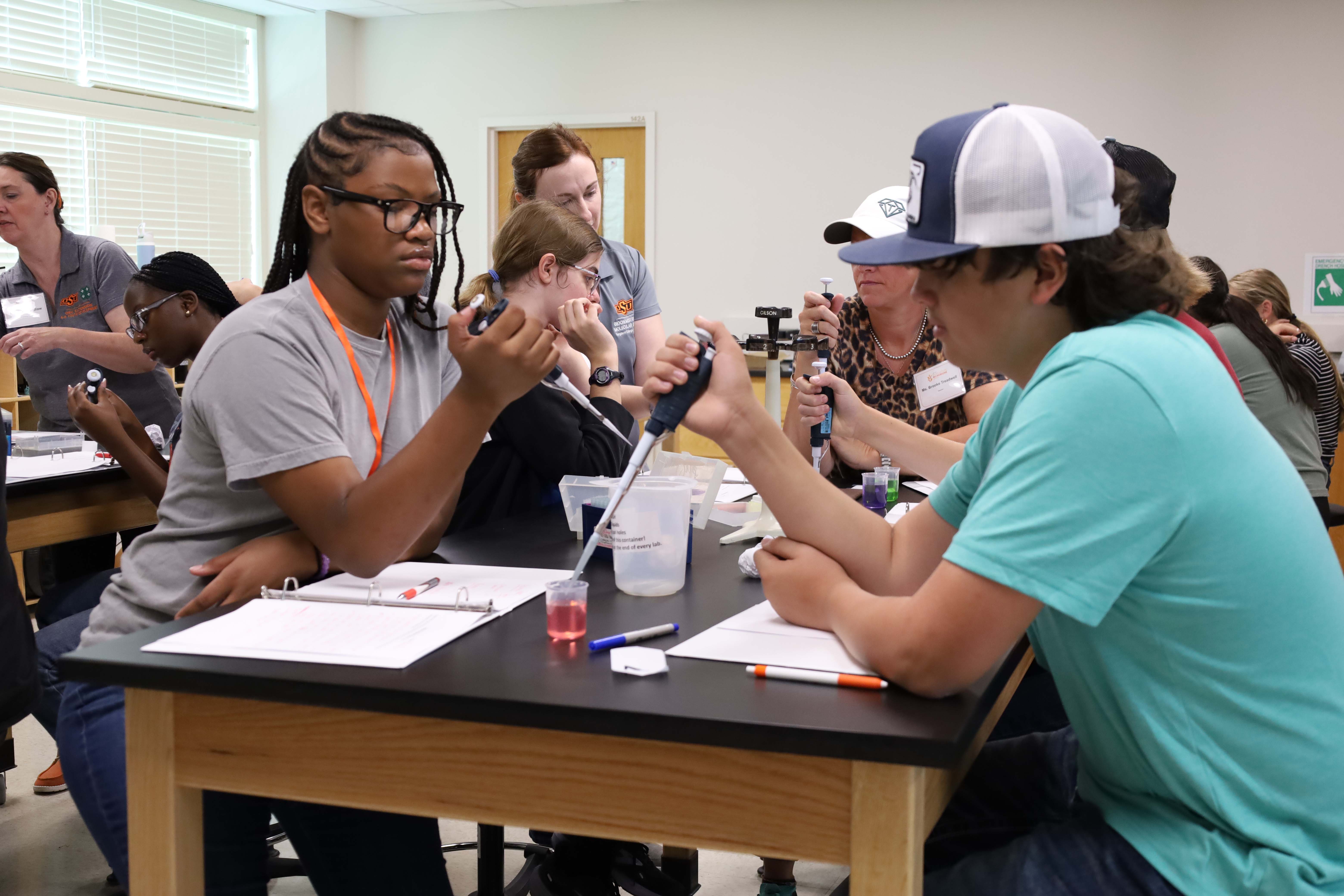 Students practicing lab techniques with pipettes Students practicing lab techniques with pipettes