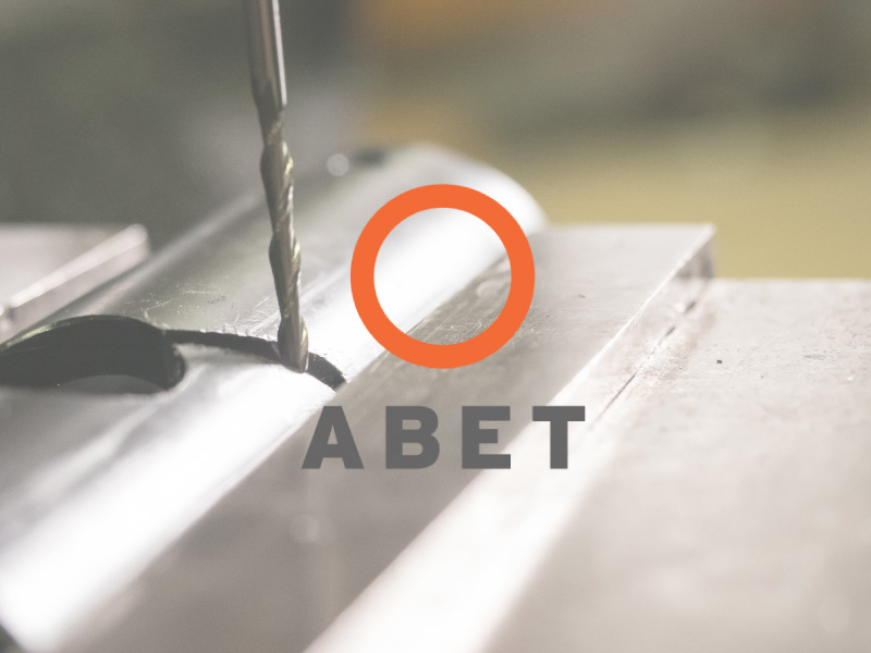 ABET logo with metal work happening in the background ABET logo with metal work happening in the background