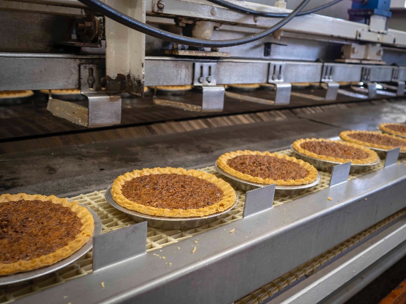 Pecan pies on processing line in a production facility. Pecan pies on processing line in a production facility.