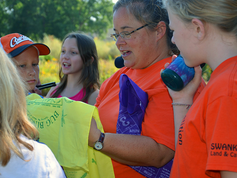 Dr. Shelley Mitchell explaining a bug bingo game to campers.
