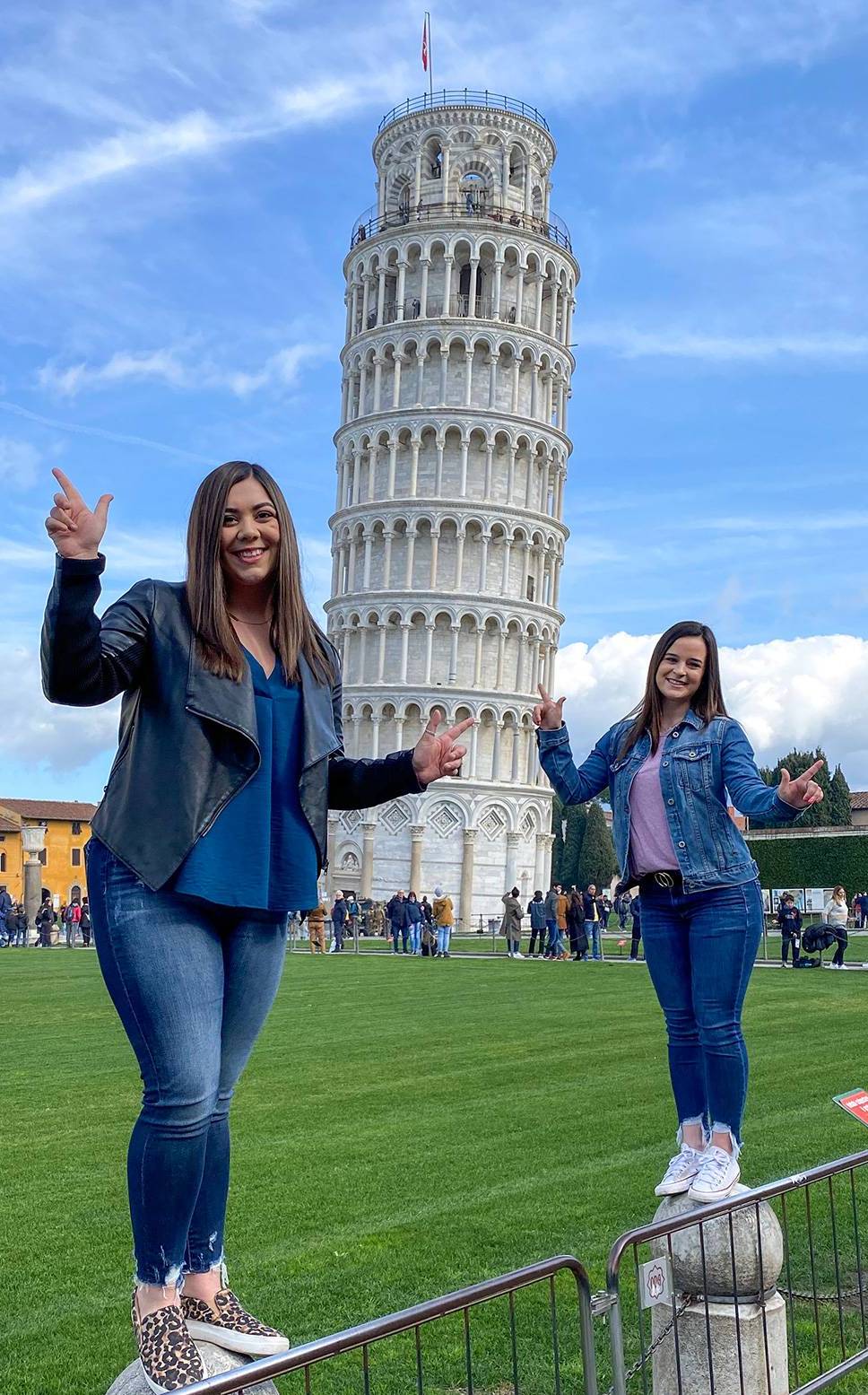 Two students standing in front of the leaning tower of pisa in Italy.