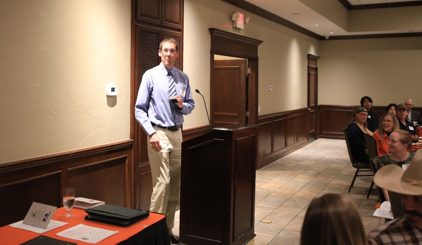scott-loss.jpg Dr. Scott Loss standing behind a podium at an award ceremony.