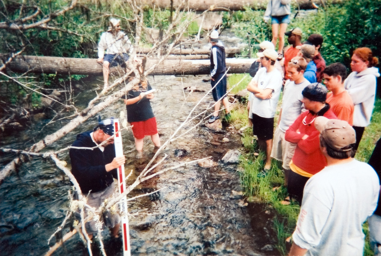 Students observing a presentation at a small stream.