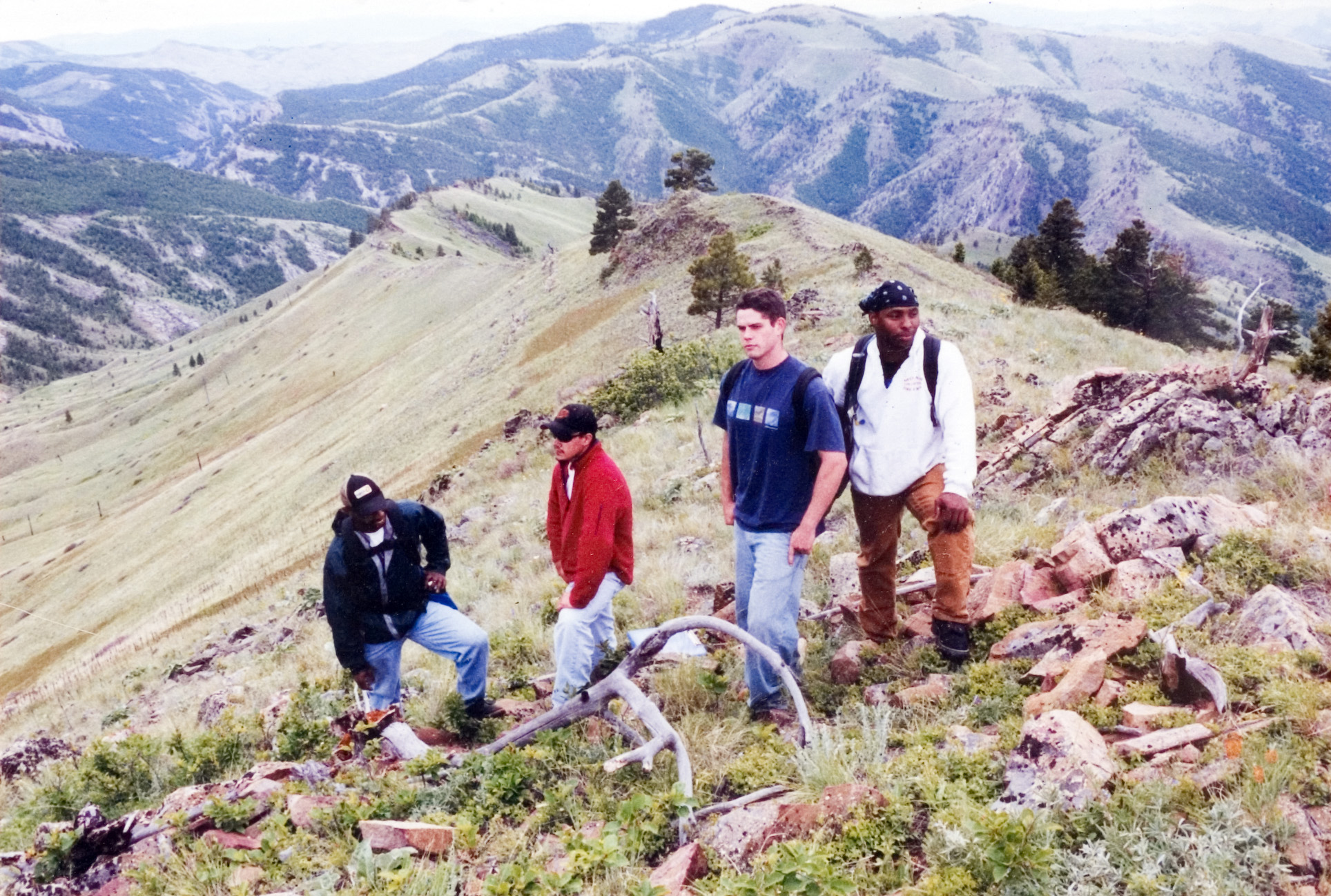 A group of students stop on top of a hill for a photo.
