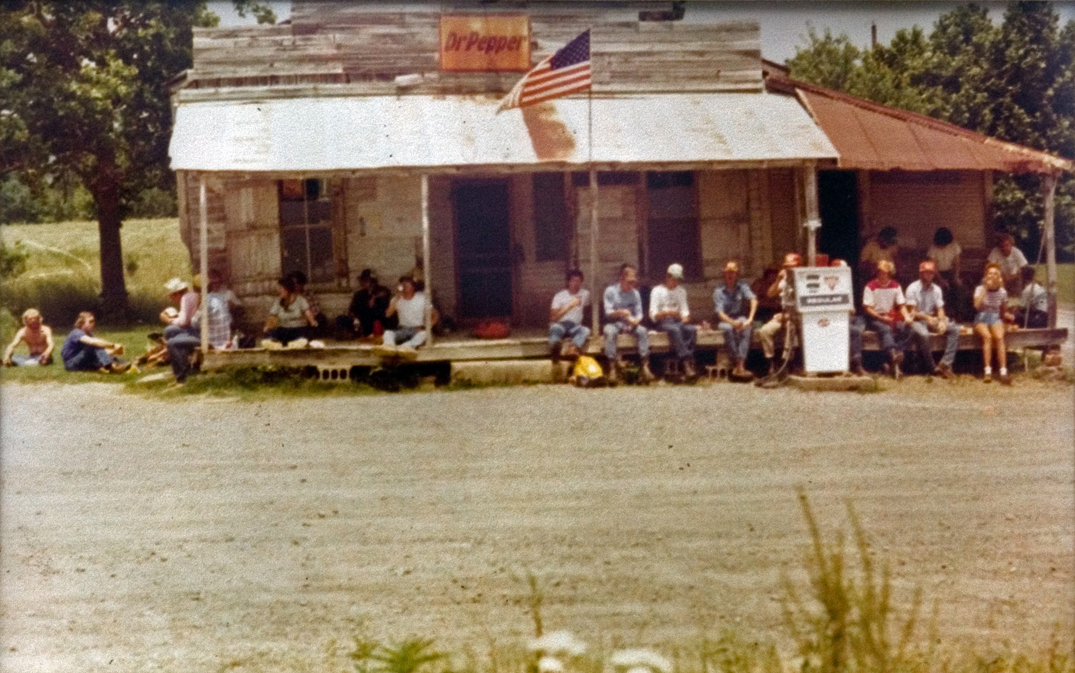 A large group of people sitting outside a building.