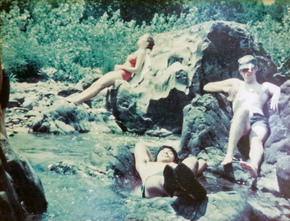 Three students laying on rocks, sunbathing.
