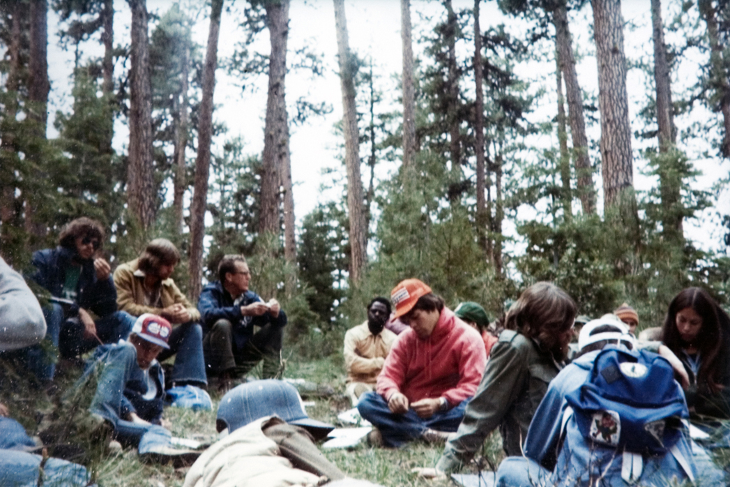 Students resting on the ground during a hike.