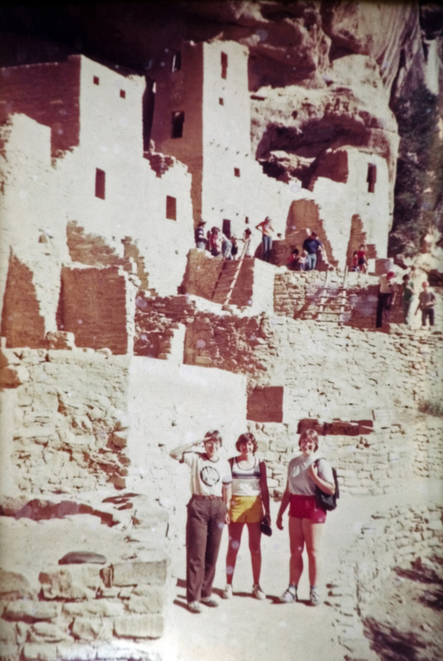 Students pose with adobe houses in the background.