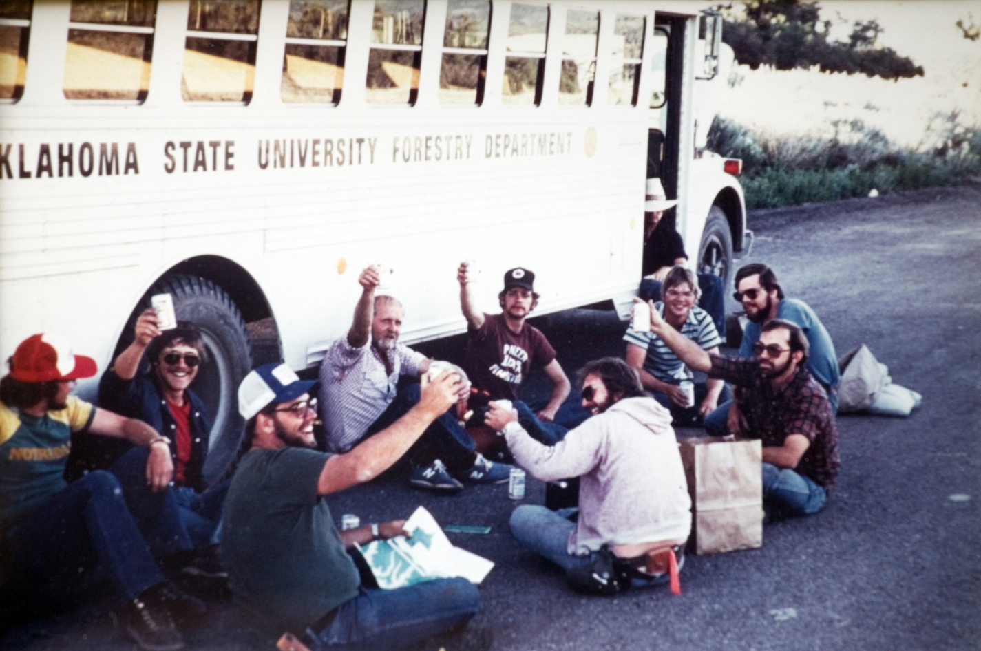The camp group cheers outside the forestry camp bus during a lunch break.