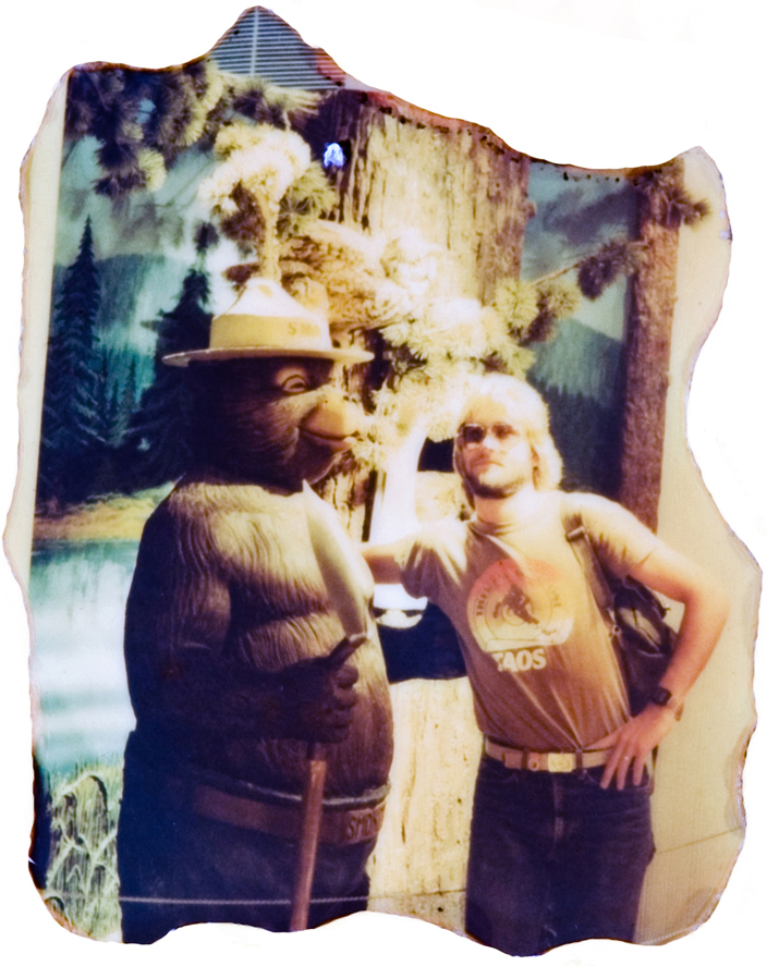 A person standing next to a bear statue.