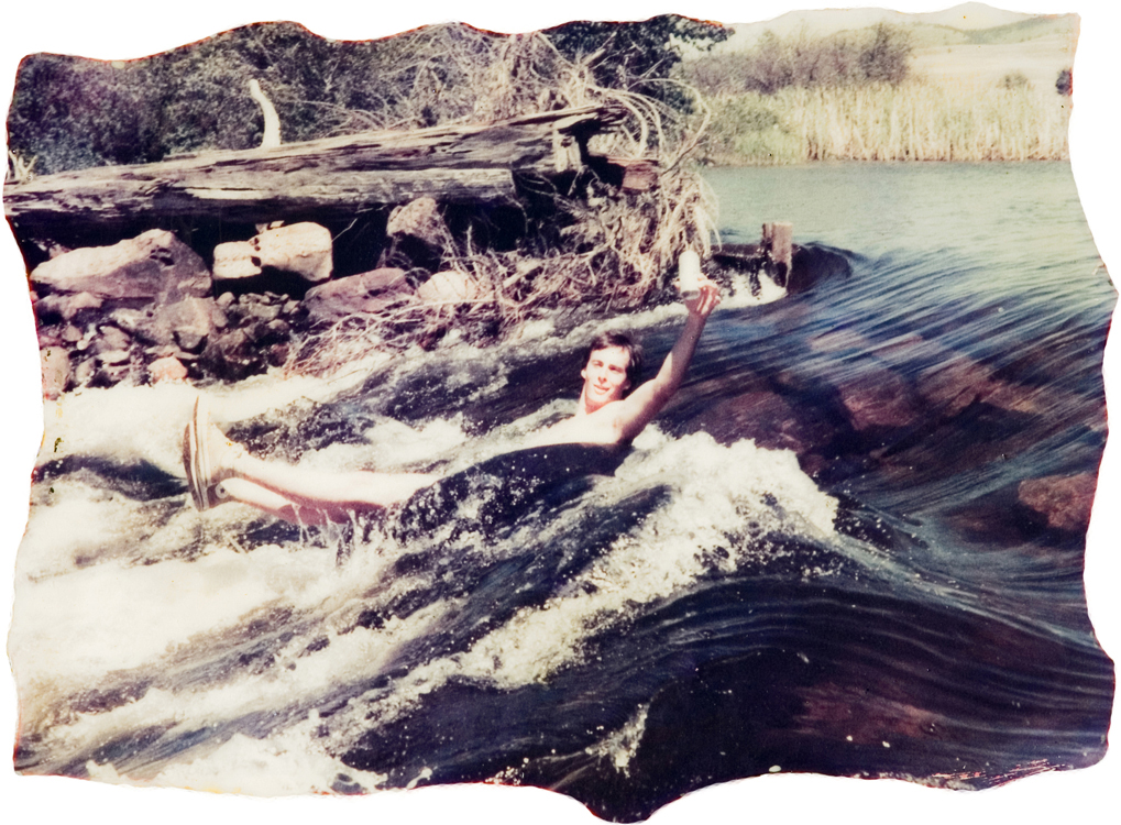 A person swimming in a stream.
