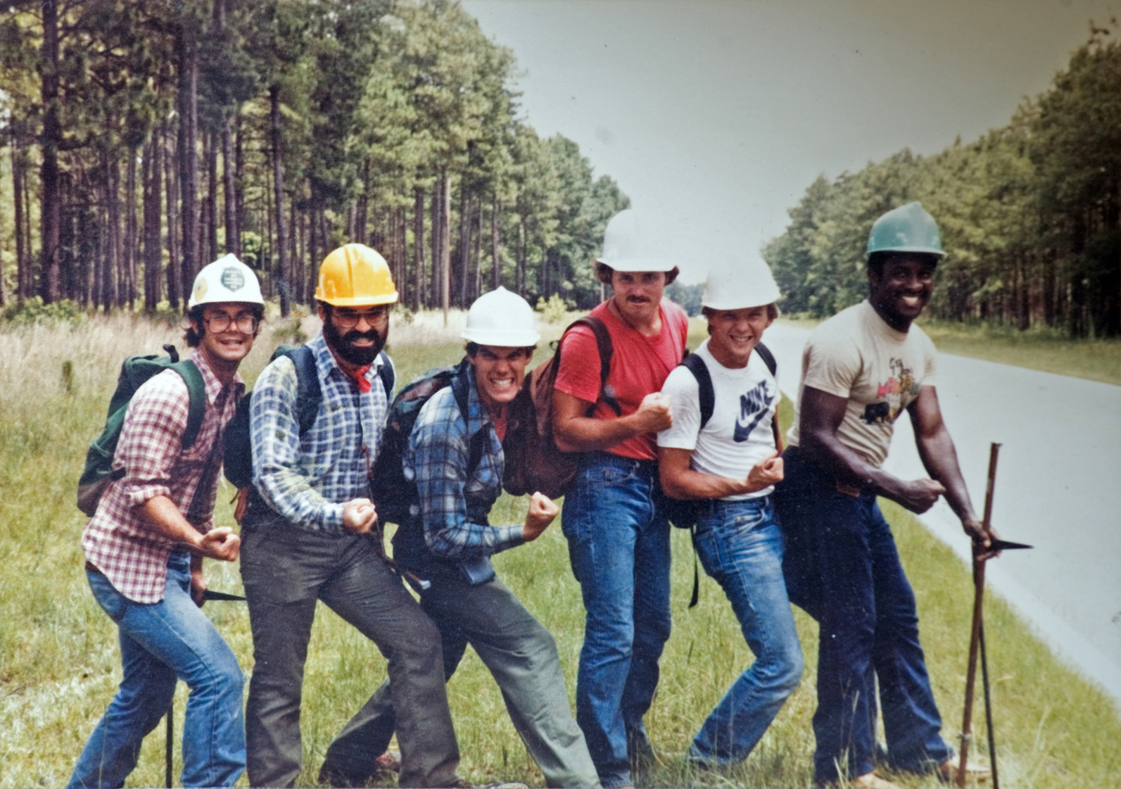Six people wearing hardhards, smiling for the camera.