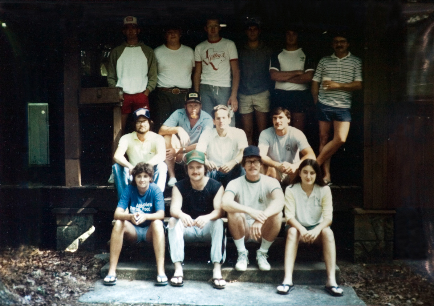 The students gather at the front steps of a cabin.