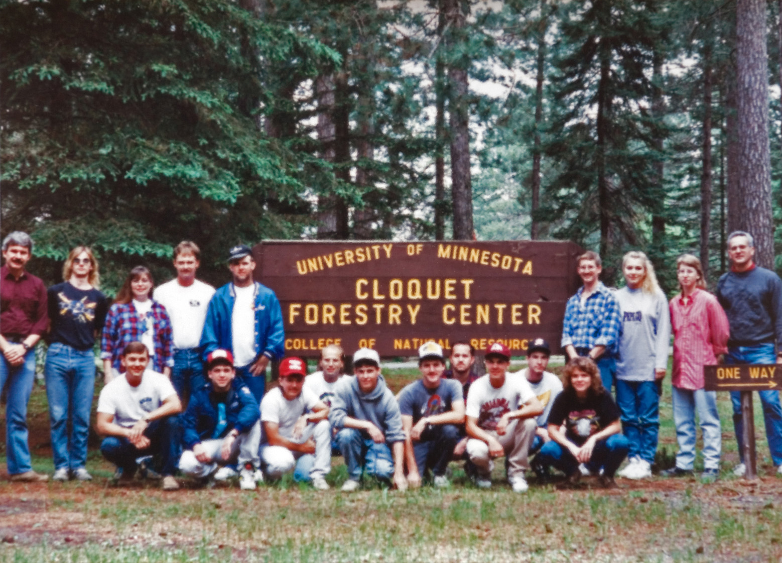 The 1991 Forestry Camp group gather for a photo at the Cloquet Forestry Center sign.