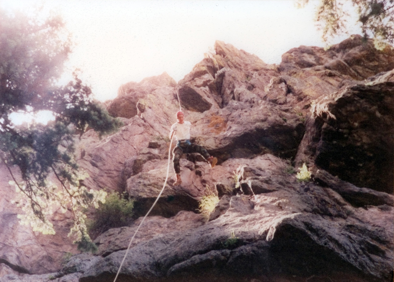 Student making a descent on a rope while rock climbing.