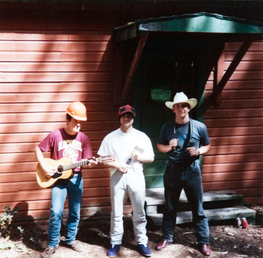 One person playing a guitar next to two other people.