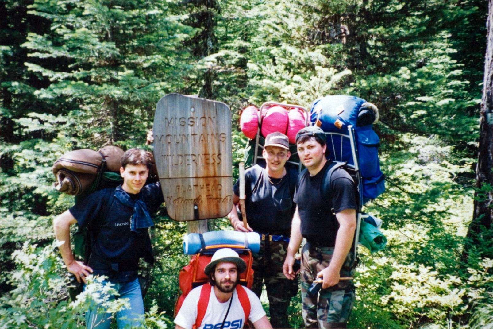 A group of people carrying camping equipment while outside.