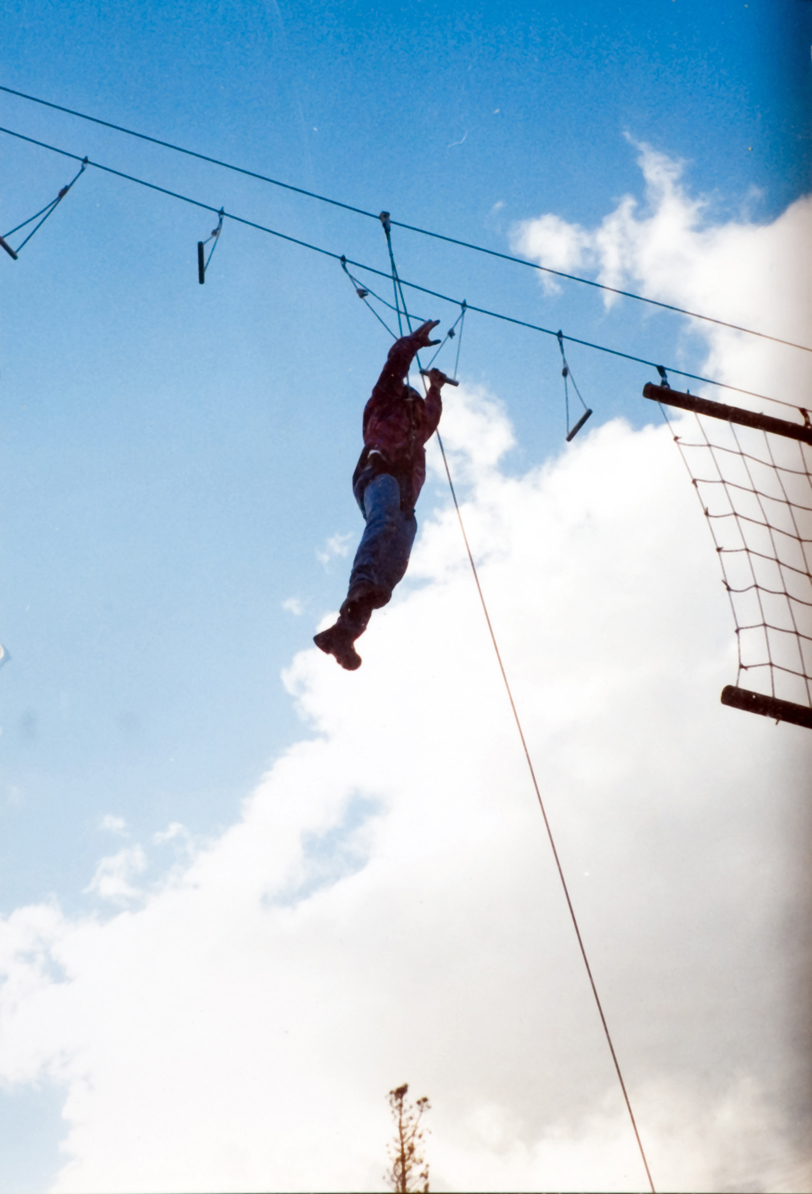A student hanging by an anchor as they climb outdoors.