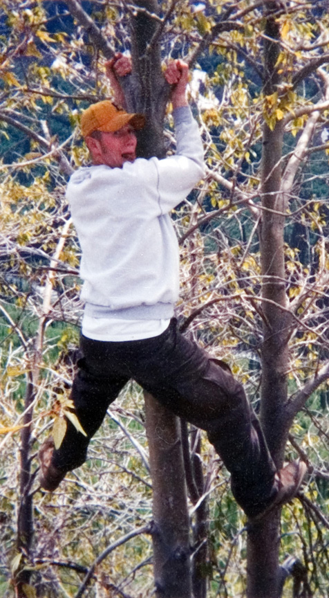 A student in a white sweater hanging from a tree.