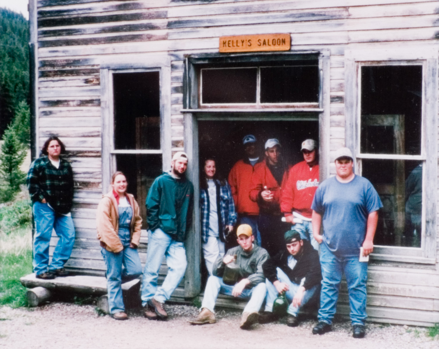 A group of 10 students in various attire standing in front of a historical Saloon.