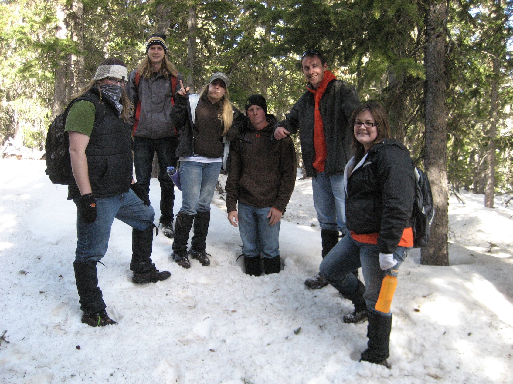A group of students standing in the snow in the woods. A group of students standing in the snow in the woods.