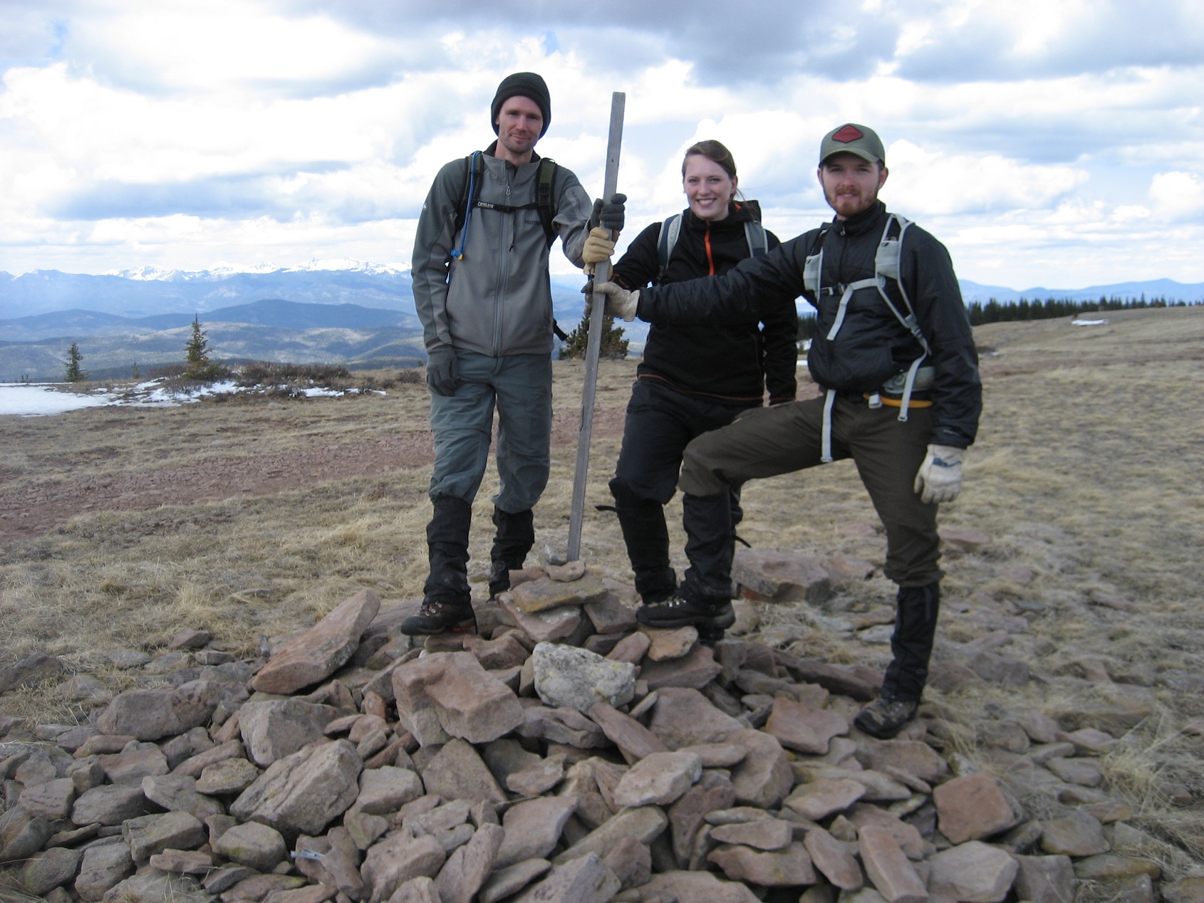 Three people standing on a pile of rocks in a valley. Three people standing on a pile of rocks in a valley.