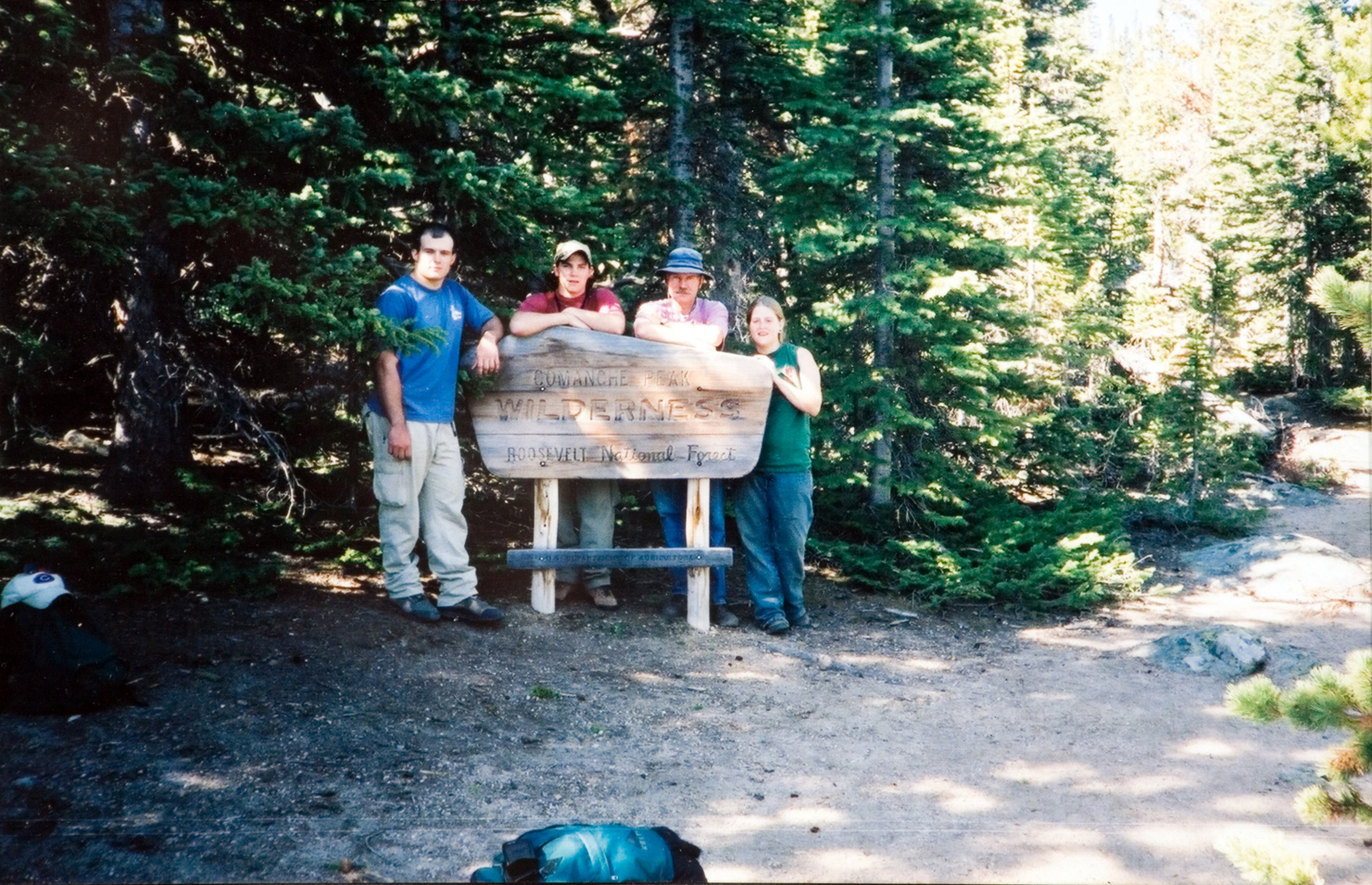 Four individuals standing behind a sign that says 