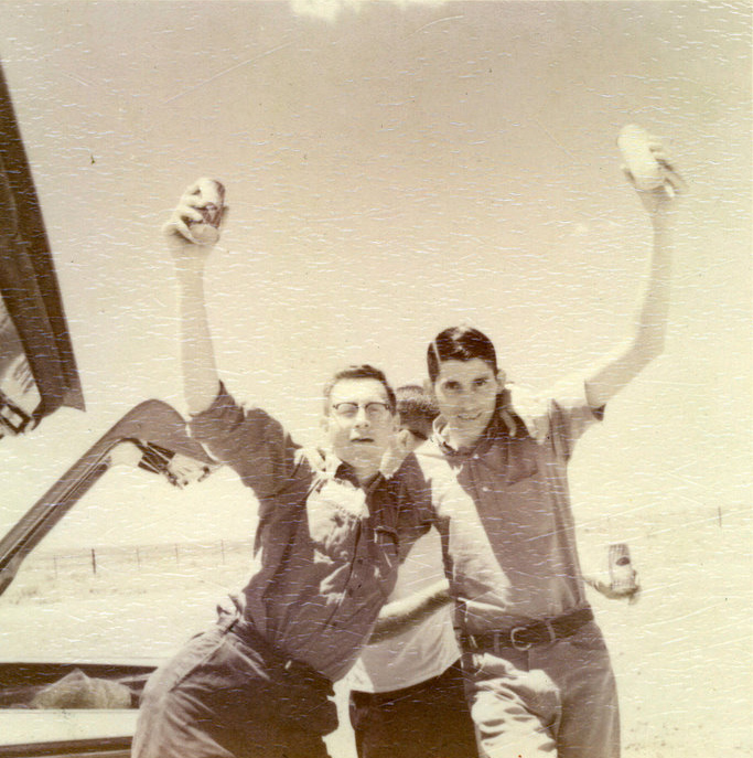 Three students with their arms around each other and holding a can in the air. Three students with their arms around each other and holding a can in the air.