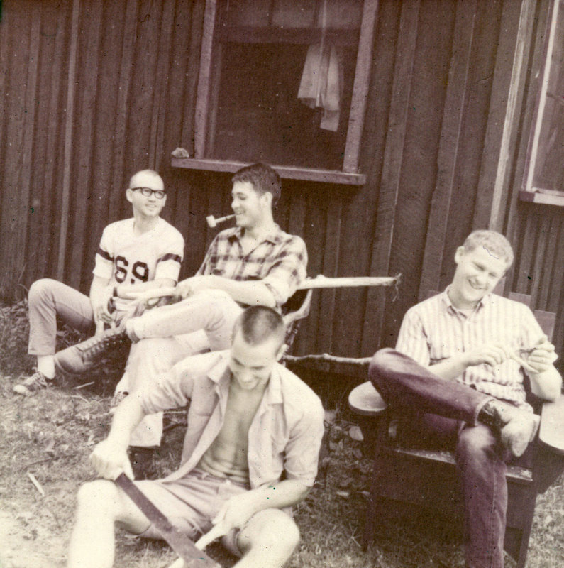 Four students sitting outside laughing. Four students sitting outside laughing.