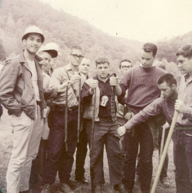 A group of people standing wearing hardhats. A group of people standing wearing hardhats.