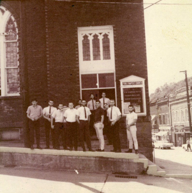 A group of people standing outside a church. A group of people standing outside a church.