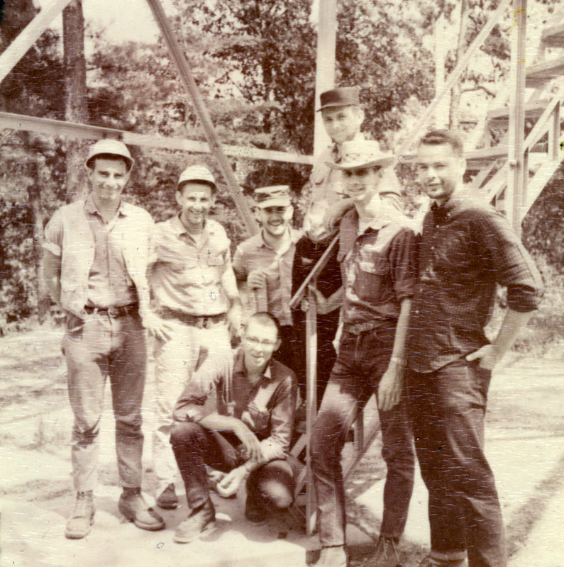 A group of people standing around steps, smiling for the camera. A group of people standing around steps, smiling for the camera.