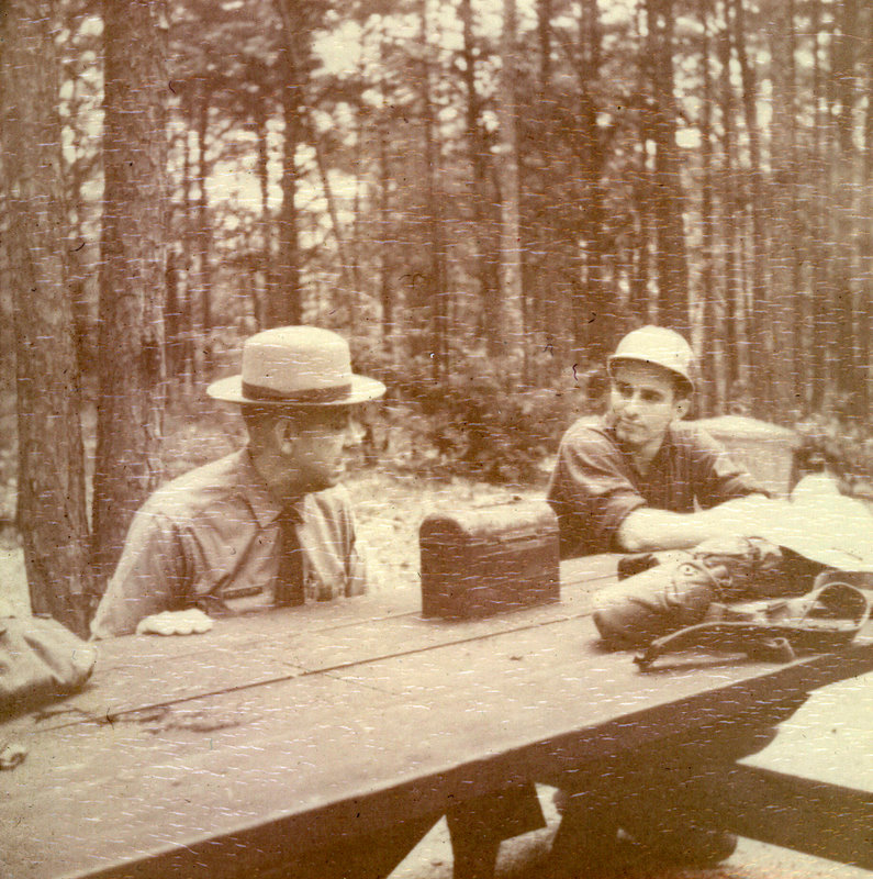 A couple of people sitting at a picnic bench. A couple of people sitting at a picnic bench.