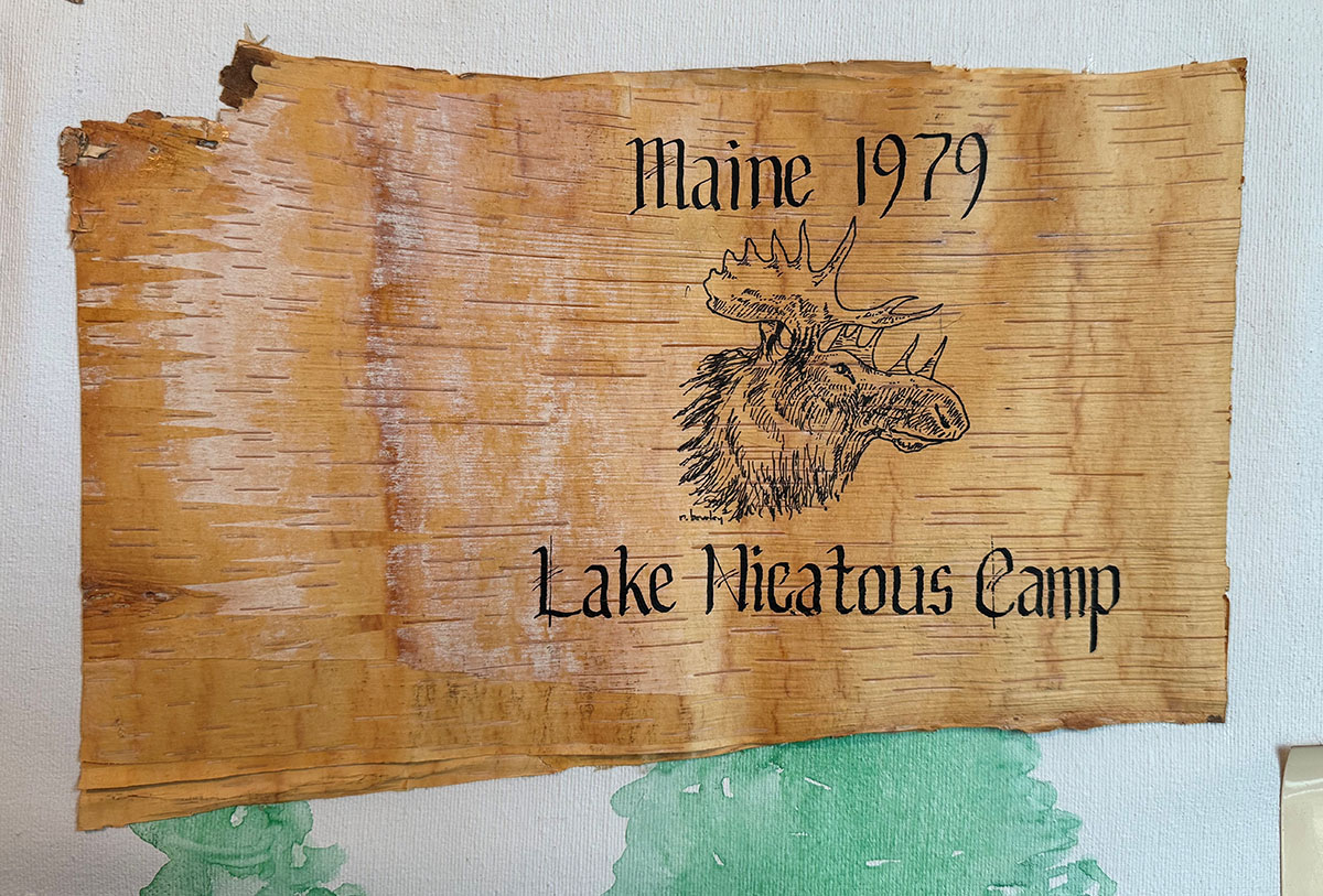 A wooden sign with a moose in the middle and text on top A wooden sign with a moose in the middle and text on top