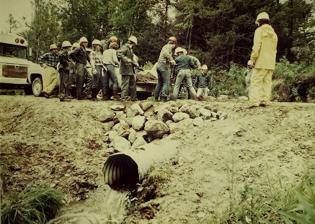 A group of people with shovels preparing the road for water drainage. A group of people with shovels preparing the road for water drainage.