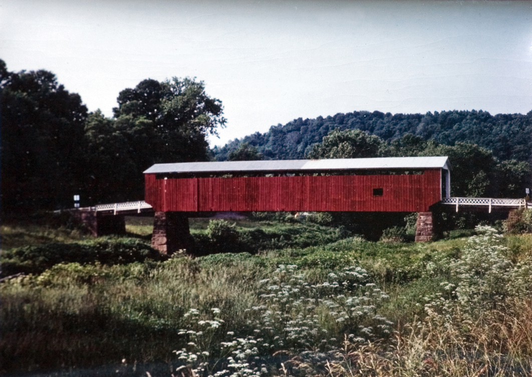 View of a red covered bridge from a distance.