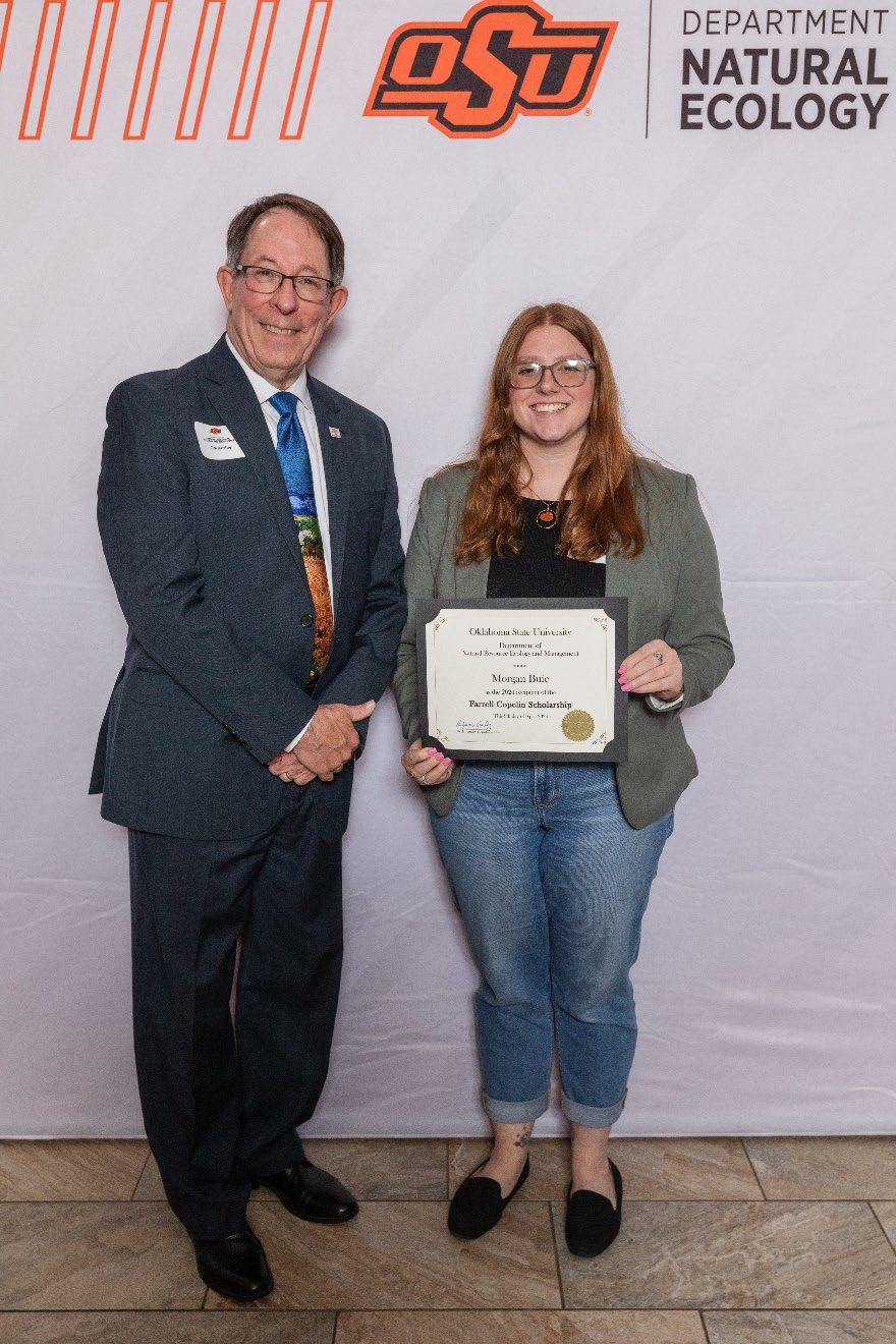 Morgan holding her award next to Dr. Jim Ansley.