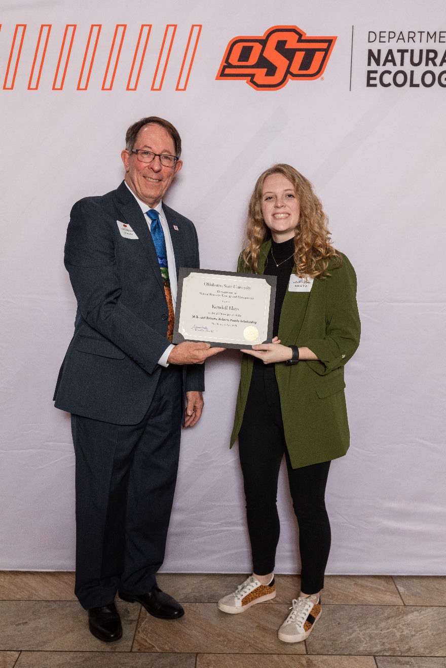 Kendall is accepting her award from Dr. Jim Ansley.