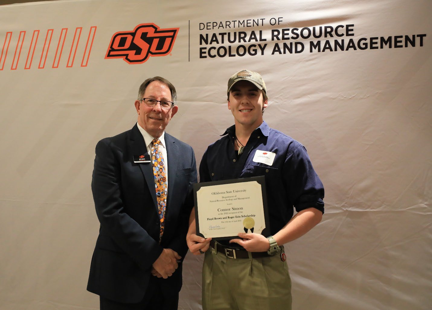 Connor Simon holding his award next to Dr. Jim Ansley.