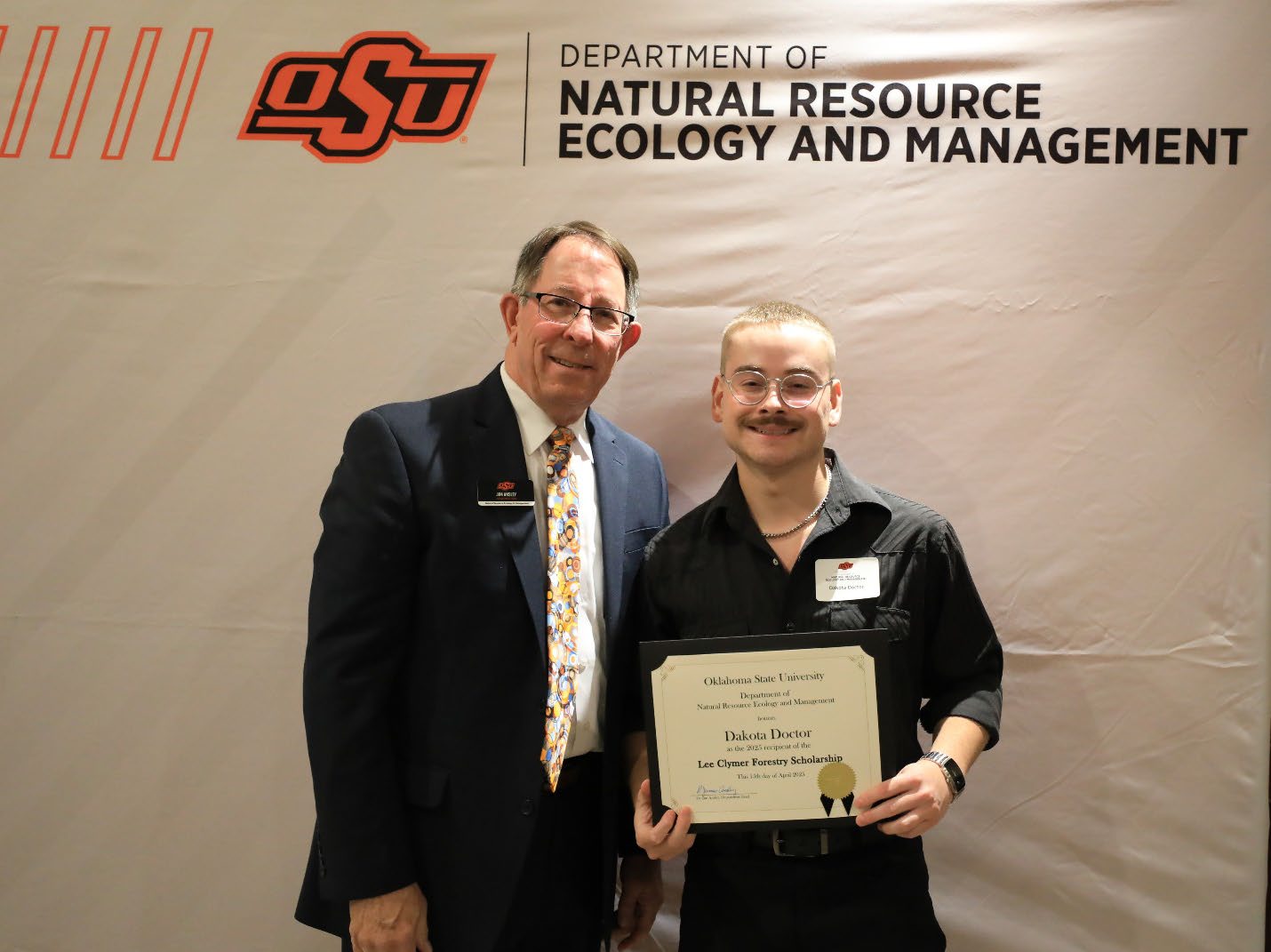 Dakota Doctor with his scholarship award next to Dr. Jim Ansley.