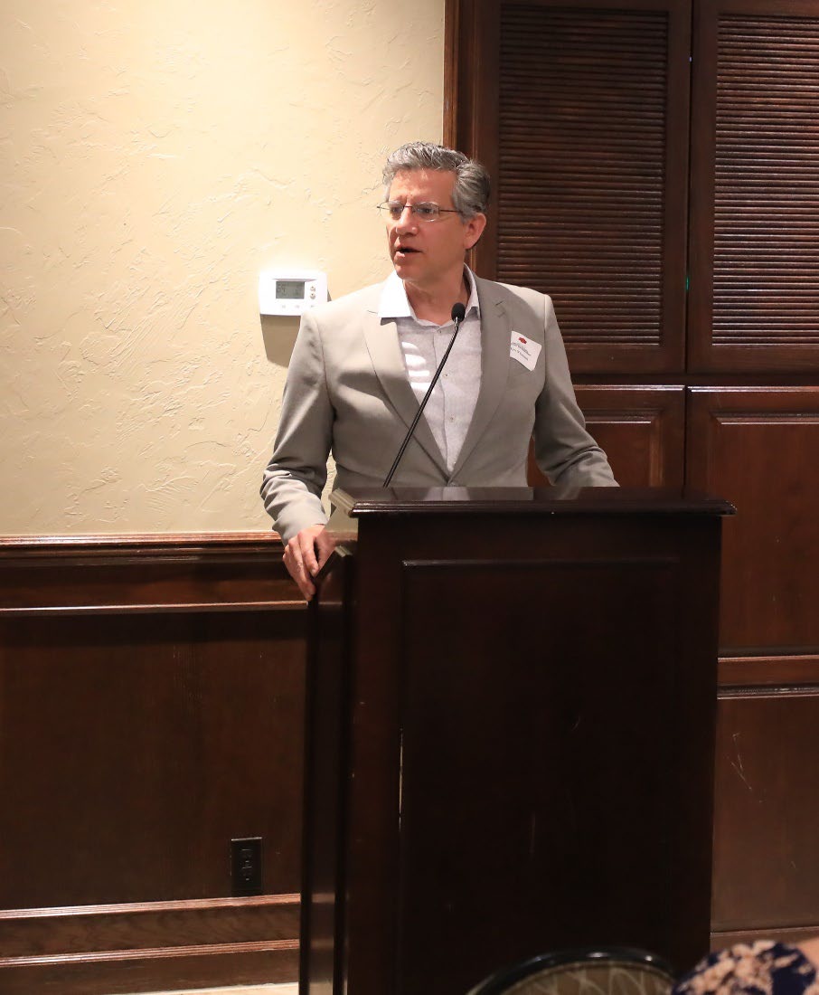 Dr. Tim O'Connell standing behind a podium at an award ceremony.