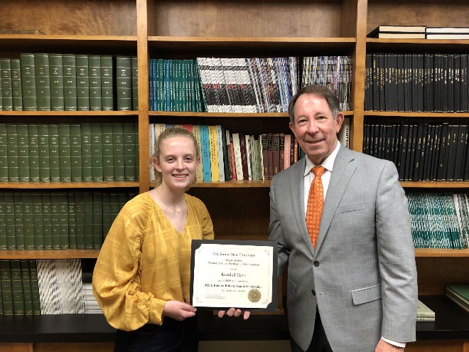 undergraduate-2022-kendall-hays-2.jpg Kendall Hays is accepting her award from Jim Ansley in front of a book shelf.
