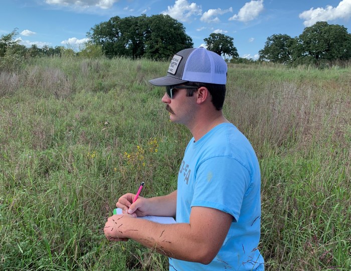 Man taking notes in the field. 