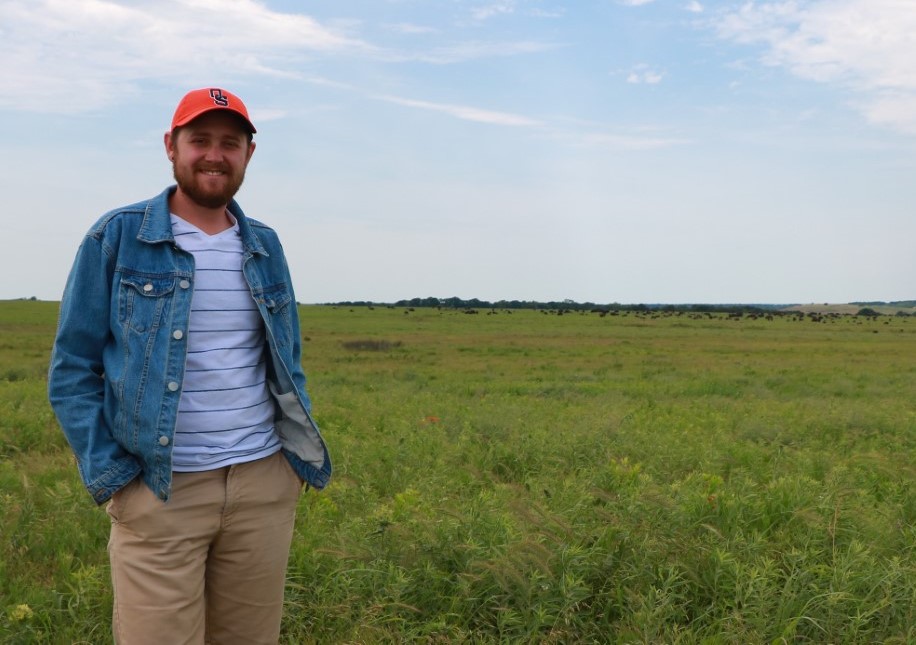 Man stands by himself with beautiful scenery behind him. 