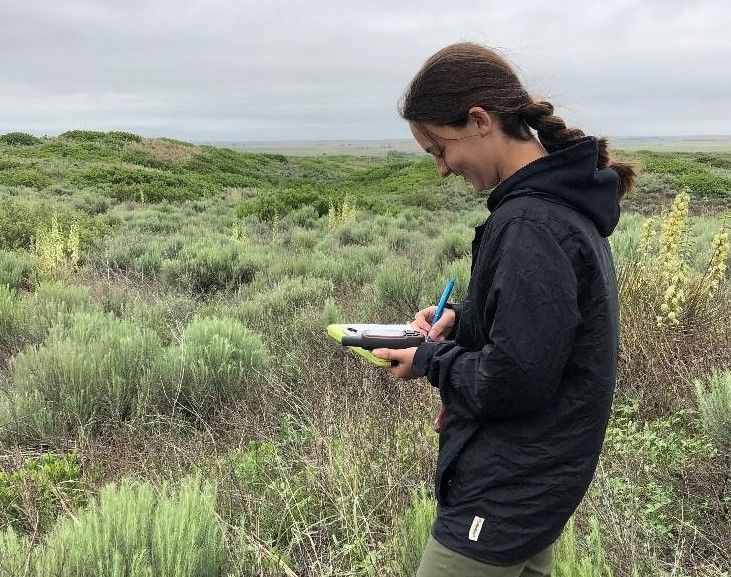 Woman taking notes outside. 