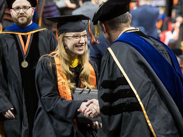 Graduate student shaking hands with professor.